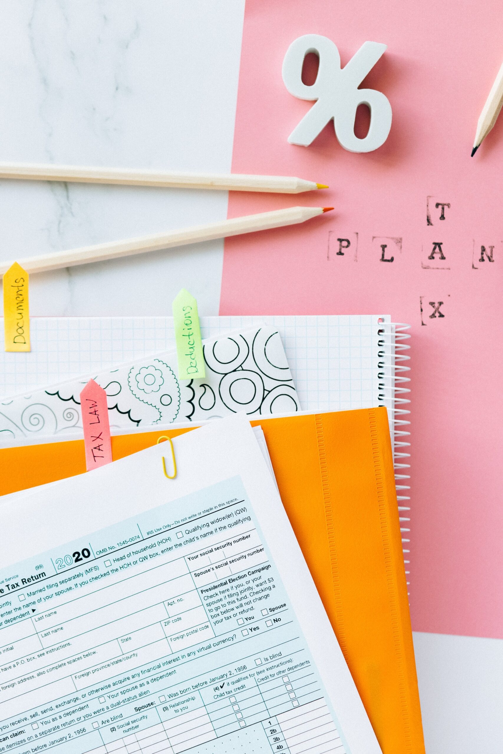 Stock photo of tax forms, pencils, coins, and a paper clip